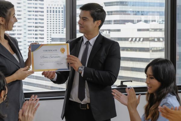 Group of employees holding certificates after training completion