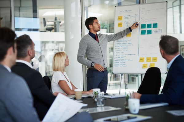 HRDC-certified trainer presenting to employees in a modern training room.